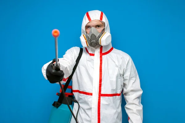 コロナウイルスに対する耐性 防護服とマスクの消毒作業員は化学スプレーを持っています青の隔離された背景のウイルス学者 — ストック写真