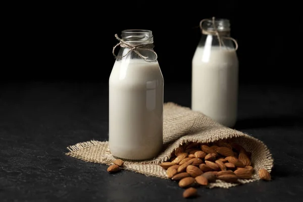 Latte Mandorle Senza Lattosio Bottiglie Con Noci Tavolo Nero Scuro — Foto Stock