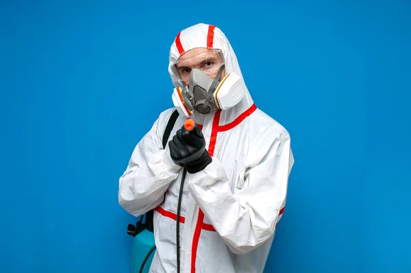 Man Chemical Protective Suit Holds Spray Bottle Blue Isolated Background — Stock Photo, Image