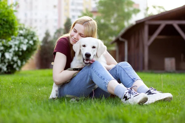 리트리버 강아지를 데리고 소녀가 거리의 잔디에 여자가 있습니다 — 스톡 사진