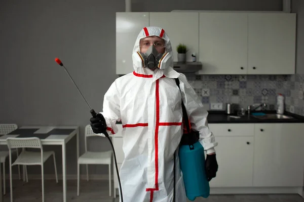 害虫駆除だ 化学スーツの男が部屋を腐敗物や虫から消毒しアパートの裏側にスプレーで衛生的な労働者 — ストック写真