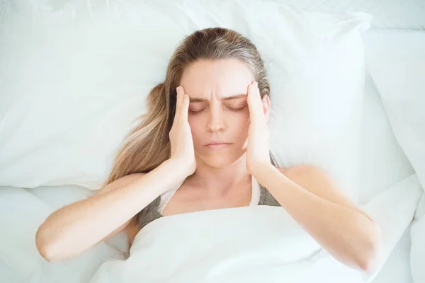 Mulher com dor de cabeça, mulher na cama — Fotografia de Stock