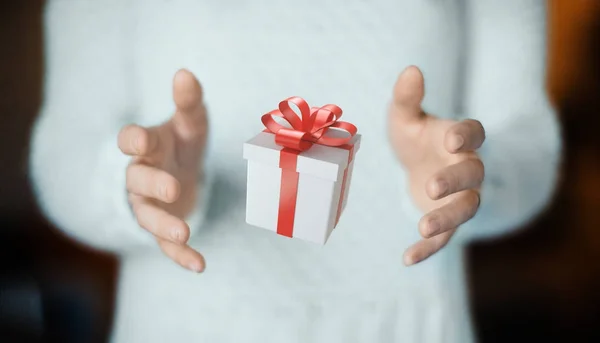 Руки з подарунковою коробкою з червоною стрічкою на Різдво — стокове фото