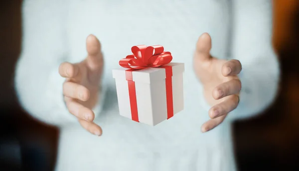 Mãos com caixa de presente com fita vermelha para o Natal — Fotografia de Stock