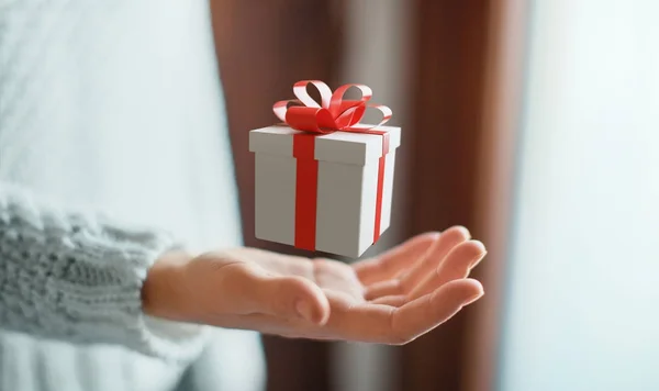 Hand with gift box with red ribbon for christmas — Stock Photo, Image