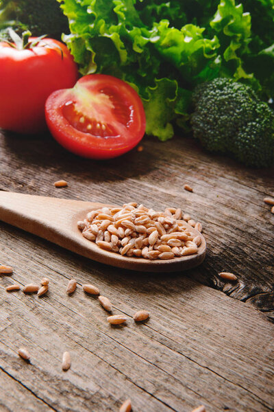 Healthy food with seeds, tomatoes and salad on wooden table