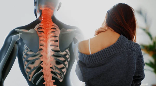 Close up of a brunette woman massaging her neck in a bedroom — 스톡 사진