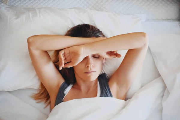 Beauty, young woman with headache on bed — Stock Photo, Image