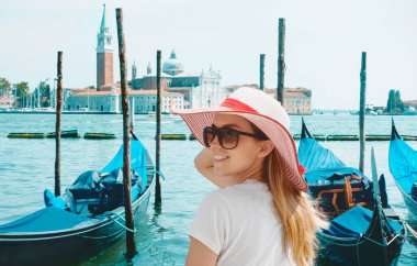 View on Grand canal with woman traveler in hat on Academia bridge in Venice. Back view