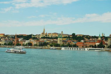 Budapeşte, Orta Macaristan / Macaristan 05: 30 2016: Tuna Nehri ile kentin manzarası. Birçok konut ve kale görünür durumda. Suda seyahat eden bir feribot var. Pastel renkler. 