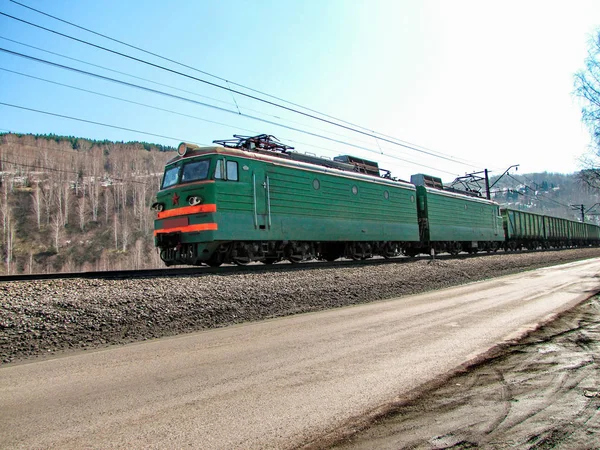 Uma locomotiva puxando vagões carregados . — Fotografia de Stock