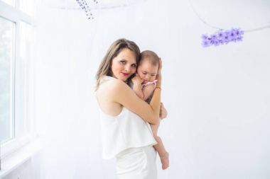 Bir güzel ve genç anne kızıyla birlikte - evde küçük bir bebek kız oynar. Mutlu bir aile fotoğrafı.