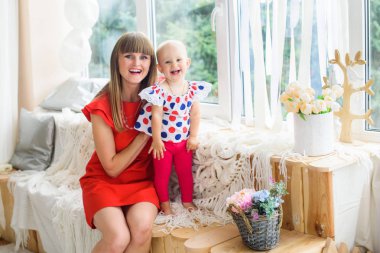 Bir güzel ve genç anne kızıyla birlikte - evde küçük bir bebek kız oynar. Mutlu bir aile fotoğrafı.