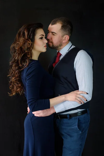 A beautiful loving couple in a living room at home on black background. A youth couple in love