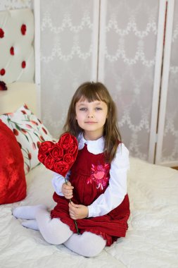 bir odada Kırmızı elbiseli kız güzel çocuk Sevgililer günü için kırmızı kalpler ile dekore edilmiş