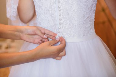 Anne beyaz ve güzel gelinliğini elbise gelin yardımcı olur.