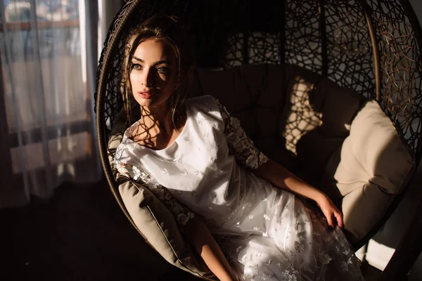 Женщина, невеста сидит на плетеном качеле. Солнечный летний день — стоковое фото