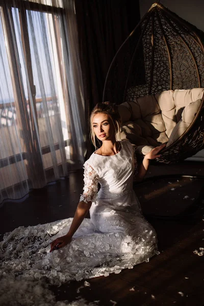 Woman, the bride sits on a wicker swing. Sunny summer day — Stock Photo, Image