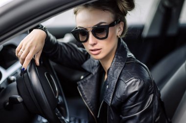 siyah deri ceket ve lüks otomatik poz güneş gözlüğü koyu saçlı seksi güzel kadın moda açık fotoğrafı