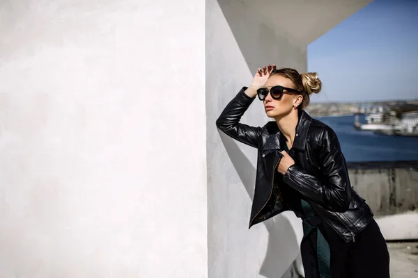 De cerca la moda; retrato de lujo de mujer sexy impresionante, labios y cara perfectos completos, gafas de sol de día soleado y chaqueta de cuero, grandes ganancias de moda, estilo urbano grunge . — Foto de Stock