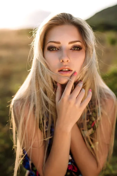 Vacker blondin med vackra ögon i blå overaller i naturen, sunset solen — Stockfoto