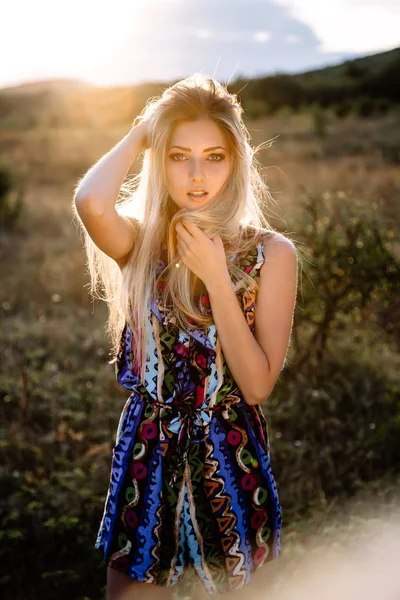 Krásná blondýnka s krásnýma očima v modré kombinéze v přírodě, západ slunce — Stock fotografie