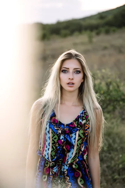 Schöne Blondine mit schönen Augen in blauen Overalls in der Natur, Sonnenuntergang Sonne — Stockfoto