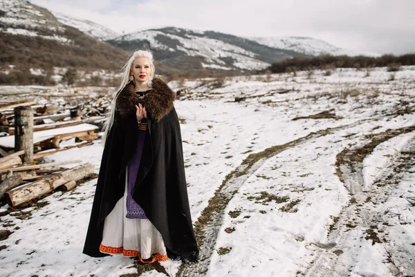 Retrato de uma bela loira em uma capa preta, viking — Fotografia de Stock