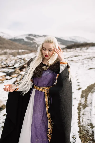 Retrato de uma bela loira em uma capa preta, viking — Fotografia de Stock