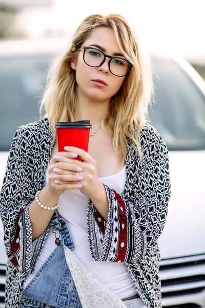 Mujer joven y elegante en una calle de la ciudad cerca de un coche blanco —  Fotos de Stock