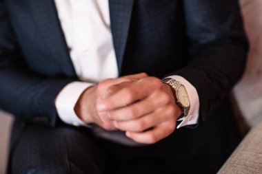 Beyaz gömlekli bir adam elindeki beyaz kadranı ile izlemek