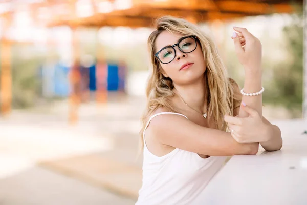 Hermosa chica, rubia con una larga camiseta blanca en la playa en un día soleado — Foto de Stock