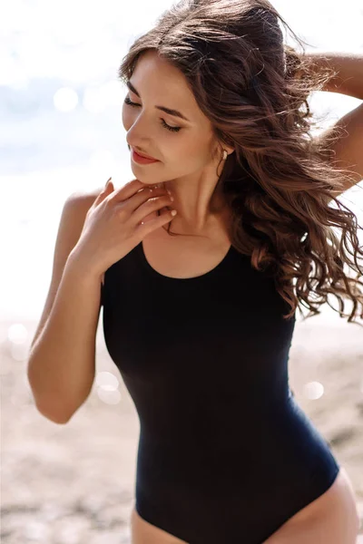 높은 패션 look.glamor 아름 다운 섹시 한 세련 된 갈색 젊은 여성 모델 완벽 한 일광욕으로 밝은 화장, 패션 스타일에서 해변에 검은 수영복에 깨끗 한 피부 — 스톡 사진