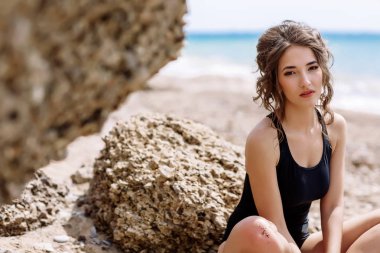 Yüksek moda look.glamor güzel seksi şık esmer genç kadın model mükemmel güneşlenme ile parlak makyajlı bir siyah mayo moda stil sahilde temiz cilt