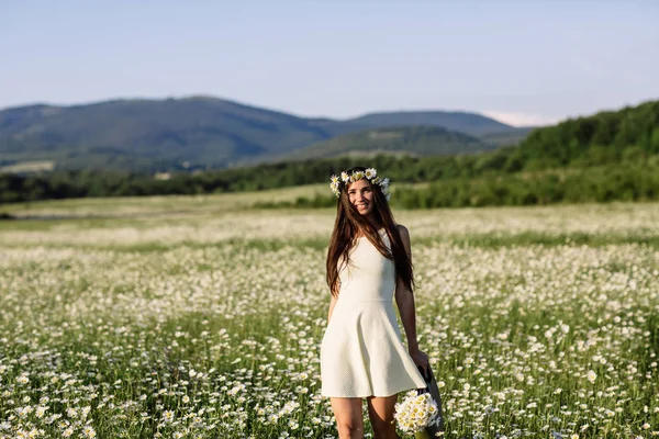 Mulher bonita desfrutando de campo de margarida, fêmea agradável deitado no prado de flores, menina bonita relaxante ao ar livre, se divertindo, segurando planta, jovem senhora feliz e natureza verde primavera, conceito de harmonia — Fotografia de Stock