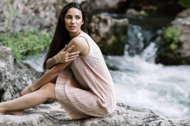 Güzel esmer nehir, su, şelale ortasında bir kayanın üzerine oturmuş. Güzel doğa, doğal ışık, yumuşak, doldurma