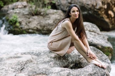 Güzel esmer nehir, su, şelale ortasında bir kayanın üzerine oturmuş. Güzel doğa, doğal ışık, yumuşak, doldurma