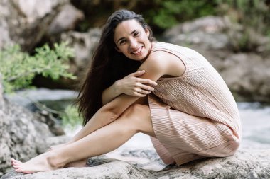 Güzel esmer nehir, su, şelale ortasında bir kayanın üzerine oturmuş. Güzel doğa, doğal ışık, yumuşak, doldurma