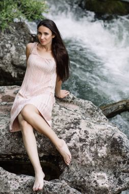 Güzel esmer nehir, su, şelale ortasında bir kayanın üzerine oturmuş. Güzel doğa, doğal ışık, yumuşak, doldurma