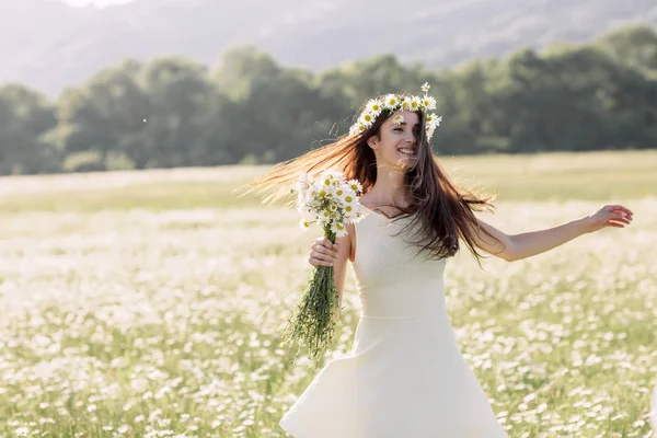 Mulher bonita desfrutando de um campo de margaridas, mulher bonita deitada em um prado de flores, menina bonita relaxando ao ar livre, se divertindo, segurando planta, jovem senhora feliz e natureza verde-primavera, harmon — Fotografia de Stock