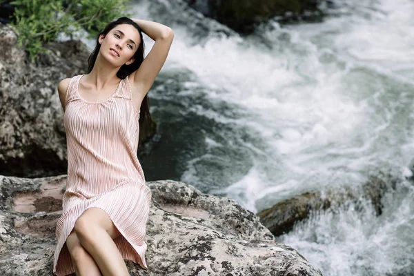 Linda morena sentada em uma rocha no meio do rio, água, cachoeira. Bela natureza, luz natural, macio, recheio — Fotografia de Stock