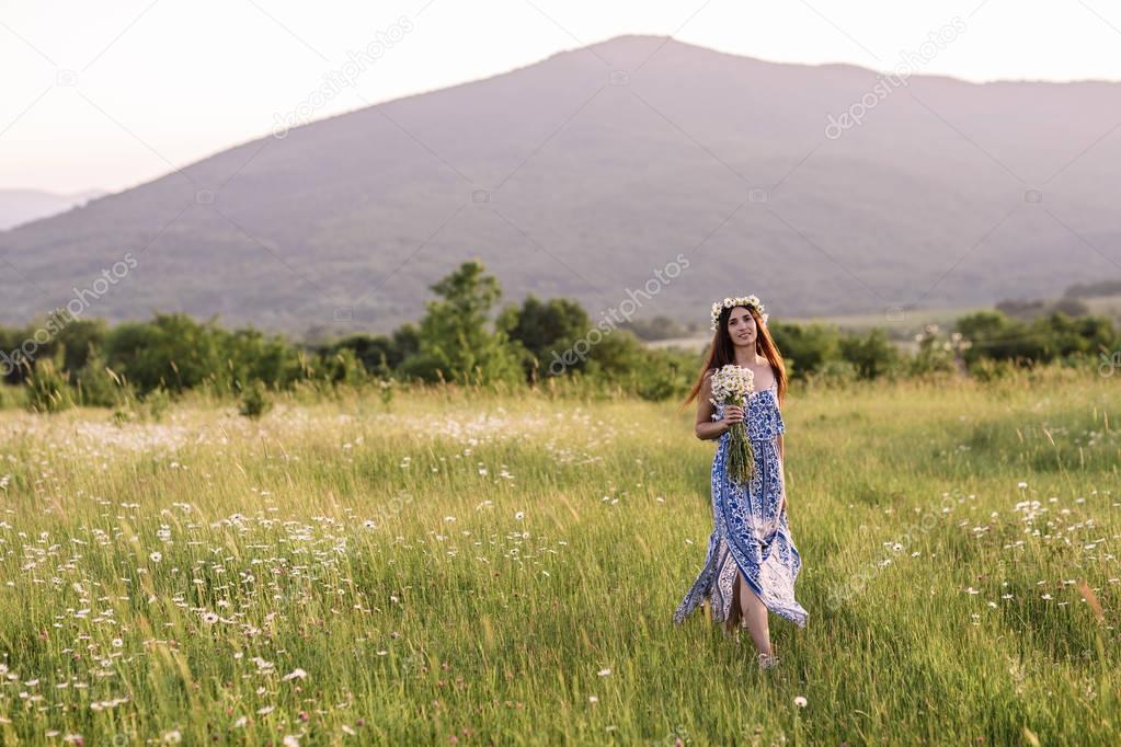 Beautiful woman enjoying daisy field, nice female lying down in meadow of flowers, pretty girl relaxing outdoor, having fun, holding plant, happy young lady and spring green nature, harmony concept