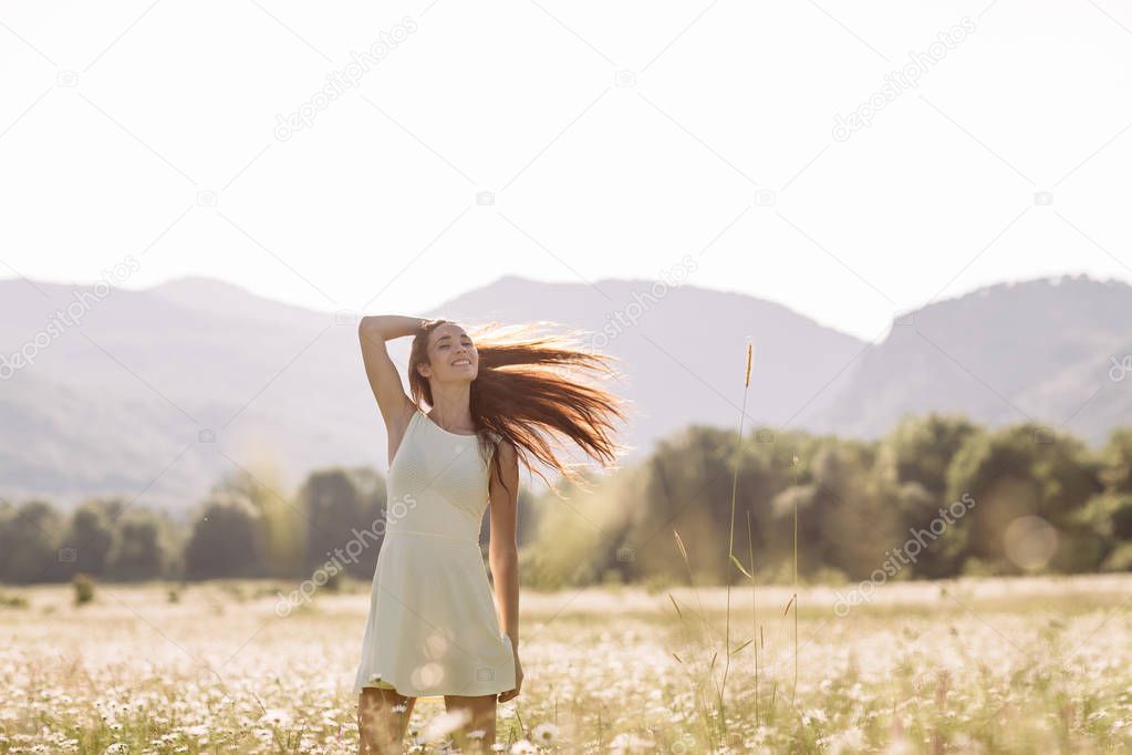 Beautiful woman enjoying a field of daisies, beautiful woman lying in a meadow of flowers, beautiful girl relaxing outdoors, having fun, holding plant, happy young lady and spring-green nature, harmon