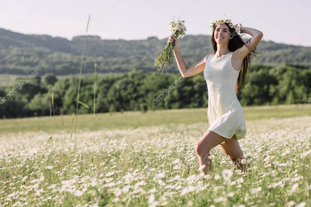 Beautiful woman enjoying a field of daisies, beautiful woman lying in a meadow of flowers, beautiful girl relaxing outdoors, having fun, holding plant, happy young lady and spring-green nature, harmon