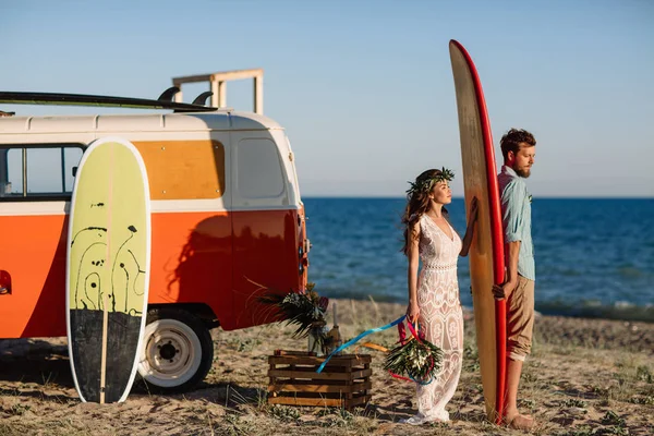 Surfers ευτυχισμένο ζευγάρι στέκεται με ιστιοσανίδες στην αμμώδη παραλία — Φωτογραφία Αρχείου