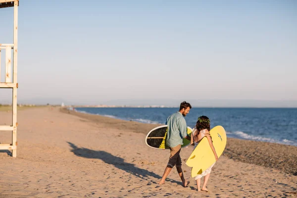 Surfers ευτυχισμένο ζευγάρι στέκεται με ιστιοσανίδες στην αμμώδη παραλία — Φωτογραφία Αρχείου
