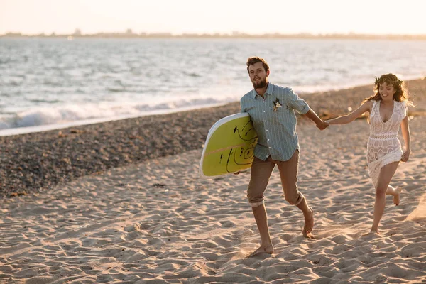 Happy surfers couple standing with surfboards on the sandy beach — Stock Photo, Image