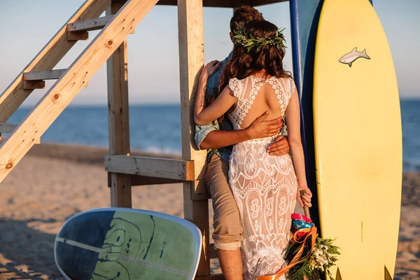 Feliz casal surfistas de pé com pranchas de surf na praia de areia — Fotografia de Stock