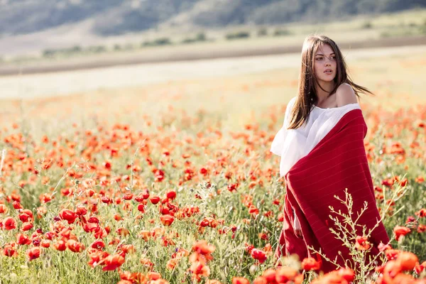 Menina bonita em um campo de papoula ao pôr do sol — Fotografia de Stock