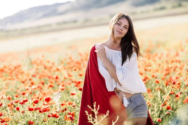 Menina bonita em um campo de papoula ao pôr do sol — Fotografia de Stock